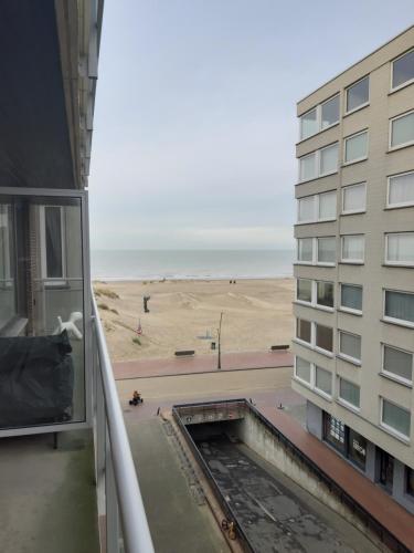 a view of the beach from the balcony of a building at Oostduinkerke Apartments in Oostduinkerke