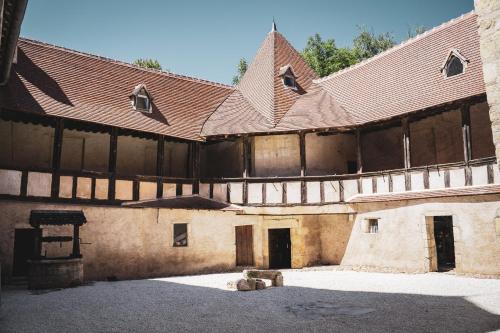 un ancien bâtiment avec un toit et une cour dans l'établissement Le Château de la Mothe de Vicq, à Vicq