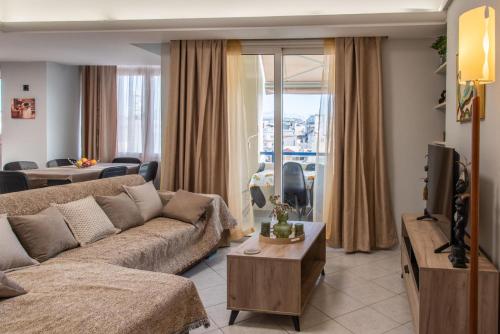 a living room with a couch and a tv at Sky 7 View Apartment in Heraklion