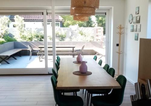 a dining room with a wooden table and chairs at Bramendijk in Groede