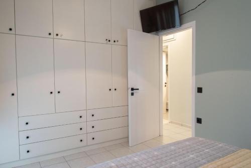 a bedroom with white cabinets and a doorway at Sky 7 View Apartment in Heraklion