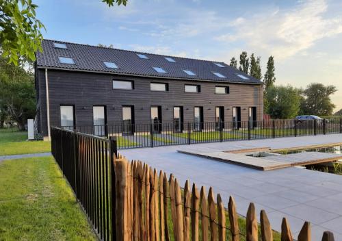 un edificio con paneles solares encima en Bramendijk en Groede