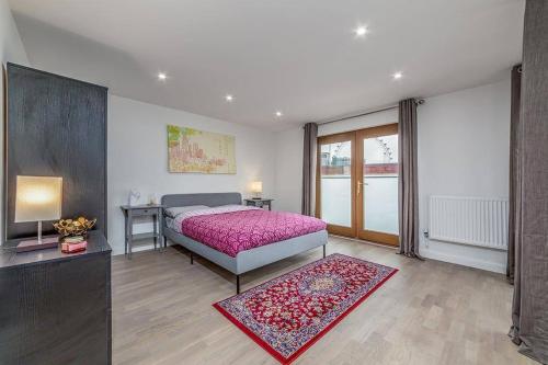 a bedroom with a bed with a pink bedspread at Amazing 2 Bed Bath Flat with London Eye View LM7 in London