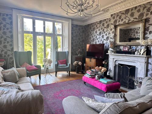 a living room with a couch and a fireplace at Stunning Georgian ‘Squires’ Town House - near London in Hertford