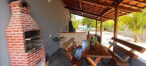 a patio with a brick oven and a wooden table at Chalé Brisa da Lagoa in Icaraí