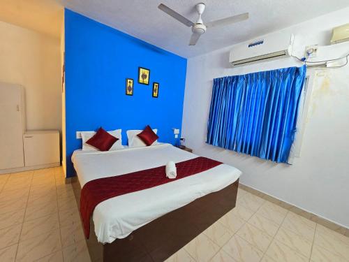 ein Schlafzimmer mit einem großen Bett mit blauer Wand in der Unterkunft SEA WALK Serenity beachside in Puducherry