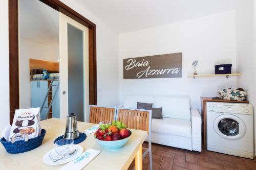 a kitchen and living room with a table with a bowl of fruit at Camping Village Baia Azzurra in Castiglione della Pescaia