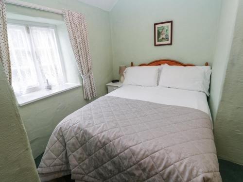 a bedroom with a bed and two windows at Honeycrock in Cubert