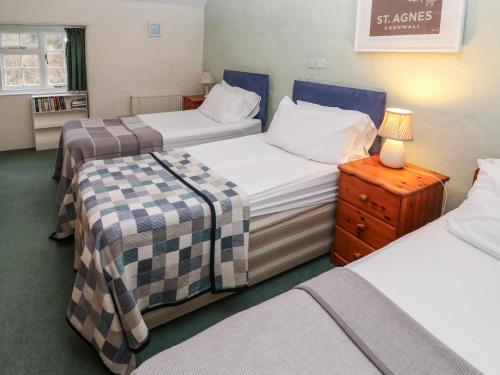 a small room with two beds and a night stand at Honeycrock in Cubert