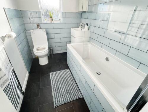 a bathroom with a white tub and a toilet at New Stylish 2-Bed Retreat in Central Windsor in Windsor