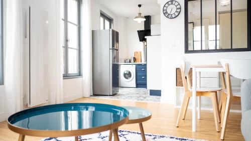 普瓦捷的住宿－Les Rives du Clain - Sublime T4 au bord de l'eau，一间带玻璃桌的客厅和一间厨房