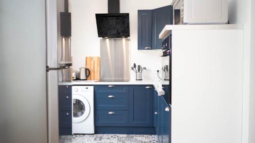 cocina con armarios azules y lavadora en Les Rives du Clain - Sublime T4 au bord de l'eau, en Poitiers