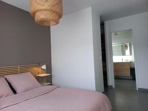 um quarto com uma cama e um candeeiro em Villa Le Clos des Oliviers em LʼEscale