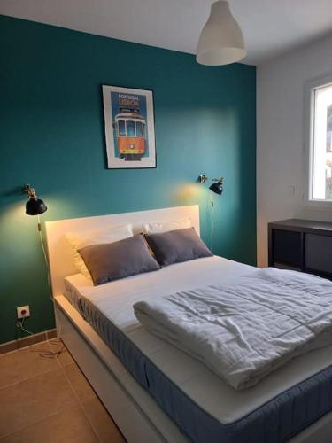 une chambre avec un grand lit avec un mur bleu dans l'établissement Villa Le Clos des Oliviers, à LʼEscale