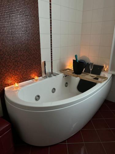 a white bath tub in a bathroom with lights at Mareincasa Dimora Luxury in Polignano a Mare
