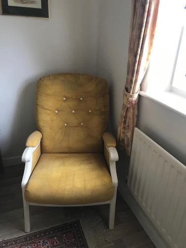 a chair sitting in a corner next to a window at 18 Wixon Path in Buckinghamshire