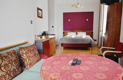 a room with two beds and a couch and a table at Chopin Boutique in Warsaw