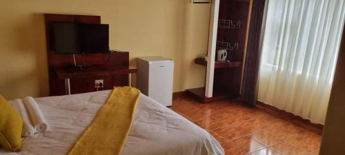 a bedroom with a bed and a television in a room at Marandela Guesthouse in Louis Trichardt