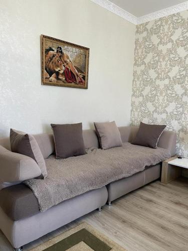 a couch in a living room with a picture on the wall at Apartment Mangilik El in Prigorodnyy