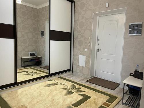 Pokój z dużym lustrem i białymi drzwiami w obiekcie Apartment Mangilik El w mieście Prigorodnyy