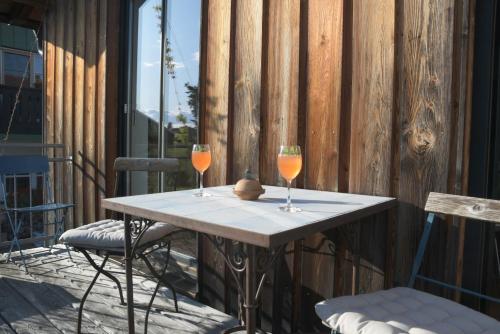 two wine glasses sitting on a table on a patio at Ferienwohnung Vogelnest in Prien am Chiemsee