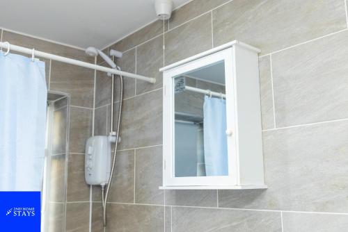 a bathroom with a shower with a mirror and a cabinet at 2ndHomeStays-West Bromwich- 2-Bedroom Maisonette in West Bromwich