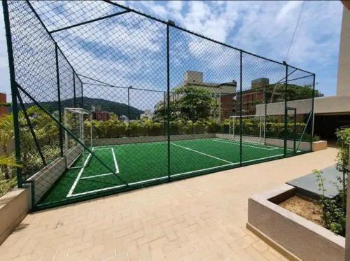 una pista de tenis en una valla con una pista de tenis en Apartamento no Guarujá - Enseada, en Guarujá
