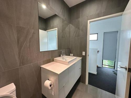 y baño con lavabo, espejo y aseo. en Best Brisbane location to enjoy vocation, en Brisbane