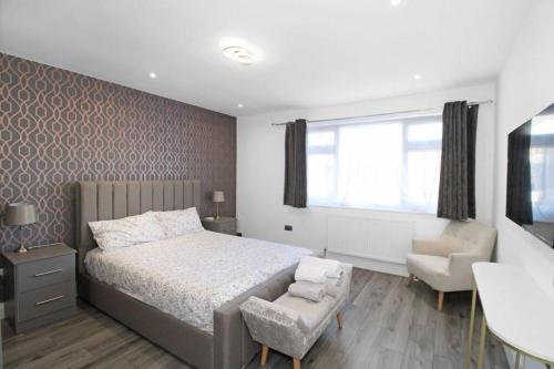um quarto com uma cama, uma cadeira e uma secretária em Stunning 2 bedroom in Luton ! em Luton