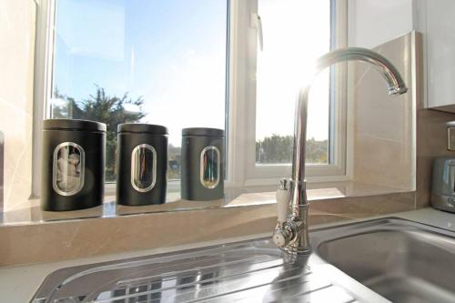 um lavatório de cozinha com uma torneira e uma janela em Stunning 2 bedroom in Luton ! em Luton