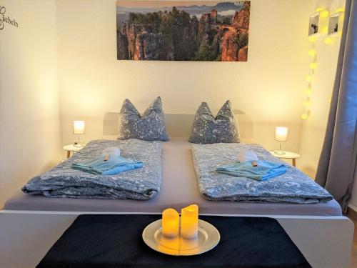 een slaapkamer met 2 bedden, slippers en een schilderij bij Urlaubsmagie - Garten, Whirlpool, Sauna - UO2 in Sebnitz
