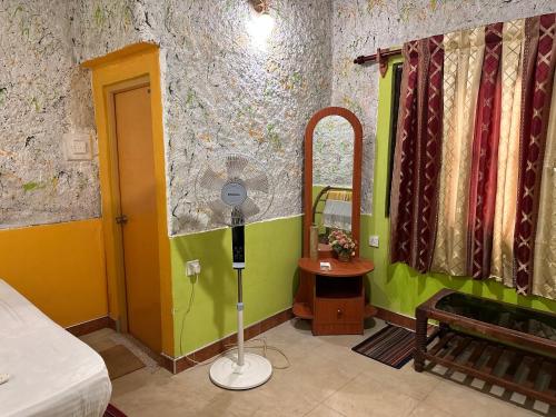 Habitación con espejo, cama y mesa. en Sigiriya Vee Guest en Sigiriya