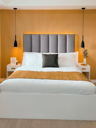 uma cama grande com uma grande cabeceira num quarto em JD Serviced Suite at Azure North Pampanga em San Fernando