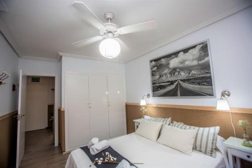 Un dormitorio con una cama y un ventilador de techo. en UNIQUE APT. W/POOL- ACROSS THE BEACH-WIFI-A/C, en Alicante