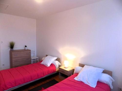 2 Betten in einem Schlafzimmer mit roter Bettwäsche und weißen Kissen in der Unterkunft Saint Palais Sur Mer - MAISON MITOYENNE - proche du Golf de Royan in La Palud