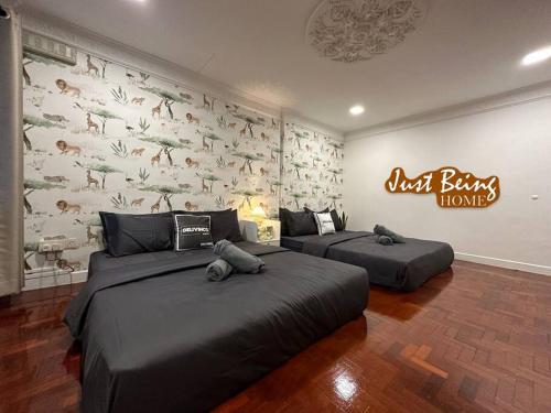 twee bedden in een kamer met een muur met dieren erop bij Just Being Home 10pax 3BR/3BA 4Queen/1Sofa in Ampang