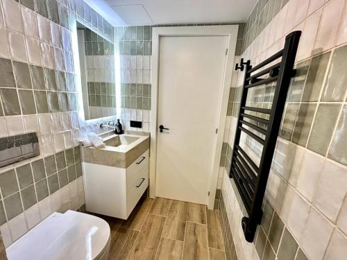 a bathroom with a toilet and a sink and a mirror at Moderno y acogedor apartamento con terraza “ Llebeig” in Sóller