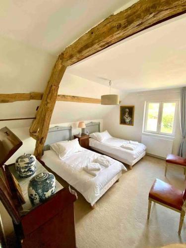 - une chambre avec 2 lits et une table avec une chaise dans l'établissement Propriété en Sologne avec étangs, à Villemurlin