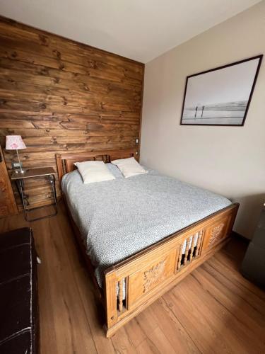 a bed in a room with a wooden wall at Puertecillo Surf Paradise - Primera Línea al Mar in Navidad