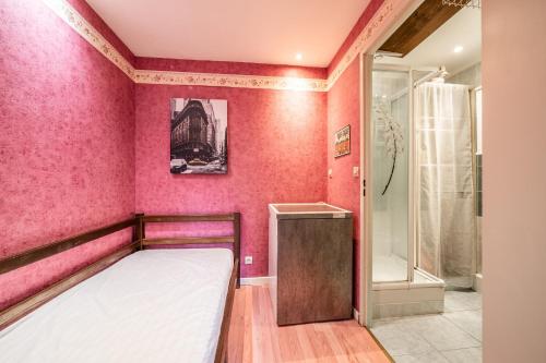 a bedroom with pink walls and a bed and a shower at Appartement Bernex - 3 personnes in Bernex