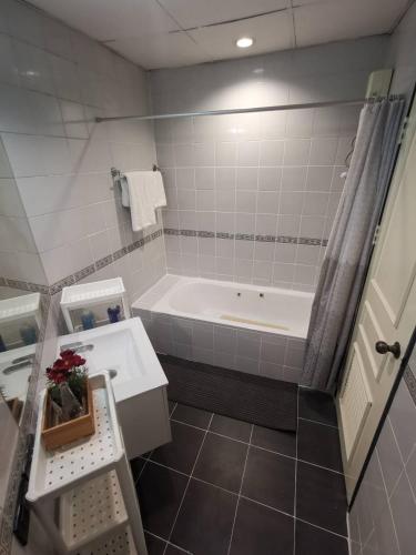 a bathroom with a tub and a sink at Cozy 1br walk to BTS and Airport Rail Link Close to Malls G7 in Bangkok