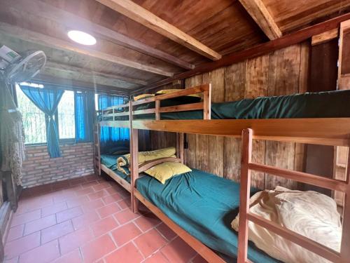 a room with two bunk beds in a cabin at Mộc An Nhiên Farmstay in Pleiku