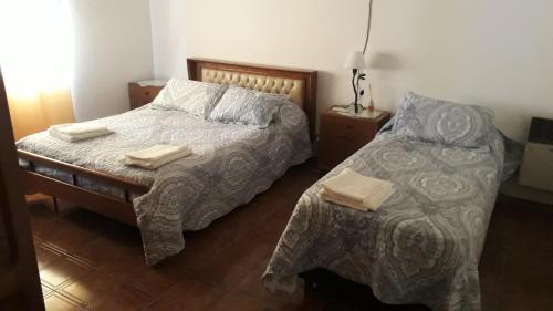 1 dormitorio con 1 cama con 2 toallas en Cabaña casa grande en San Antonio de Areco