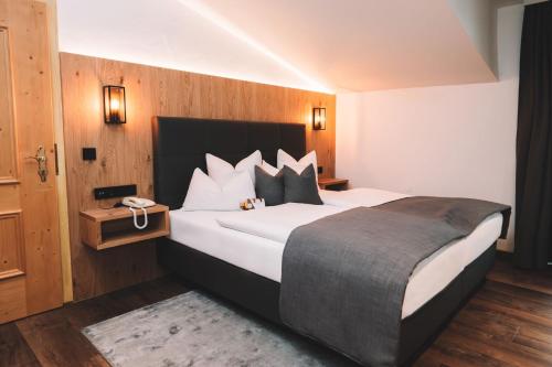 un grande letto in una camera d'albergo con telefono di Hotel Alphof Stubaital a Fulpmes