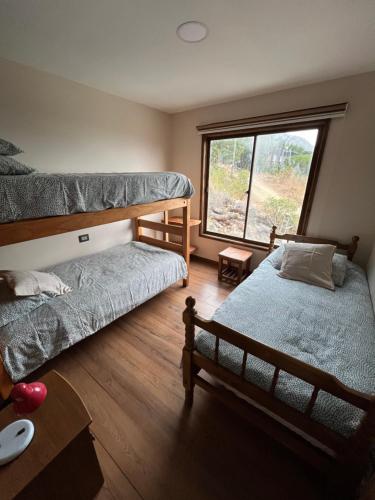 a bedroom with two bunk beds and a window at Moderna Casa - Playa Puertecillo in Navidad