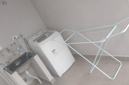 uma máquina de lavar roupa num canto de um quarto em Kitnet 3 - próximo ao centro de Jacareí em Jacareí