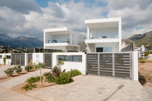 a large white house with a fence at Villa Marina Hills in Makry Gialos