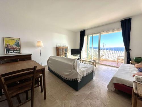 - un salon avec un lit, un bureau et une fenêtre dans l'établissement HYETOUZE T2 pour 4 personnes vue mer et port- Hyères Port, à Hyères