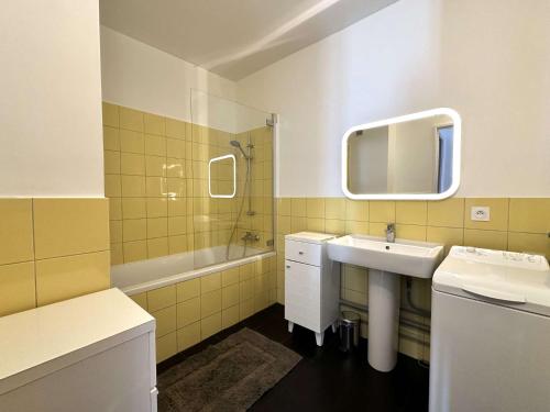 une salle de bain avec un lavabo, une baignoire et un miroir dans l'établissement HYETOUZE T2 pour 4 personnes vue mer et port- Hyères Port, à Hyères