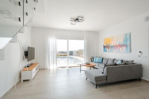 a living room with a couch and a tv at Villa Marina Hills in Makry Gialos